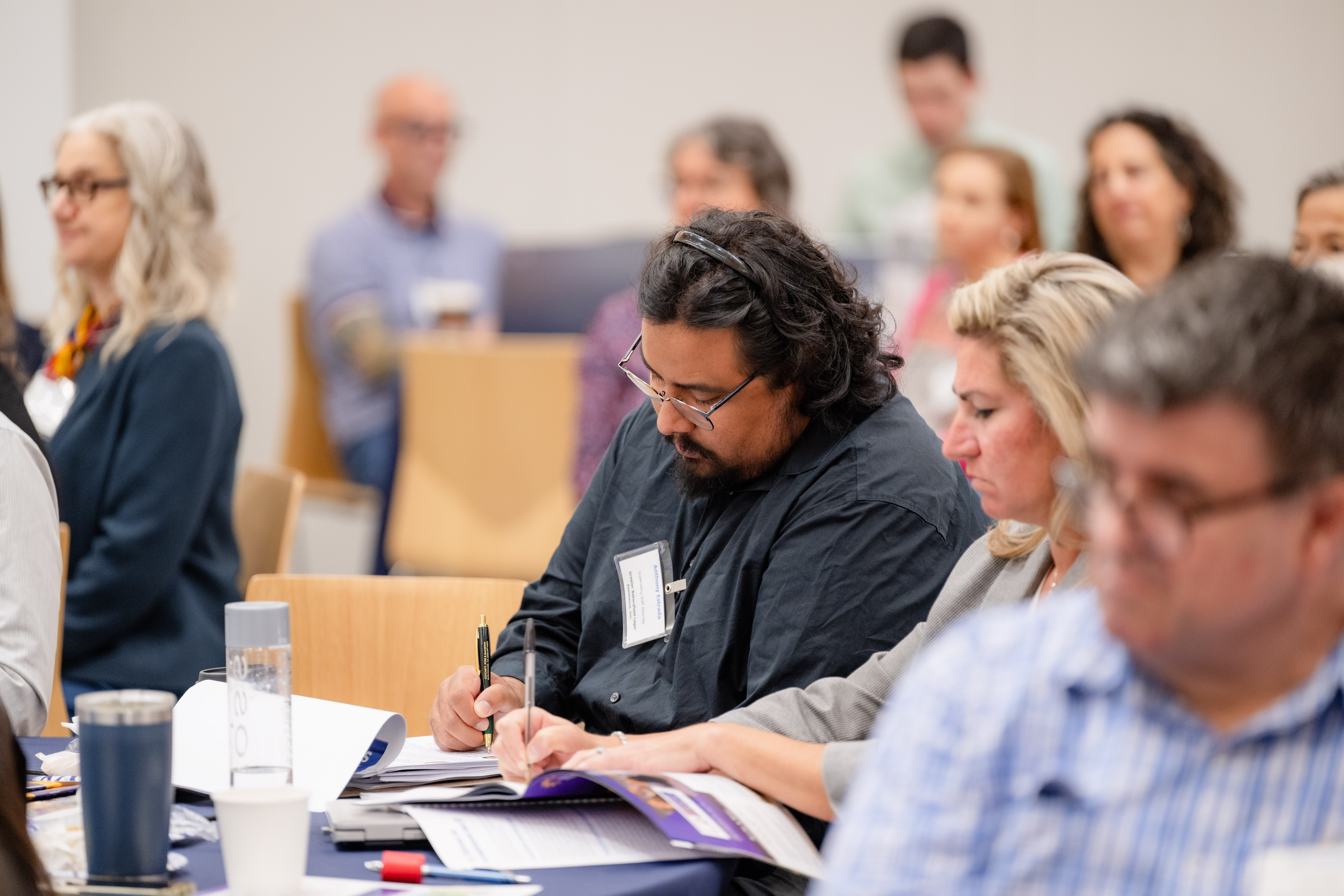 An attendee taking notes at the A conference panel at the 19th Conference on Elder Abuse (May 2025)